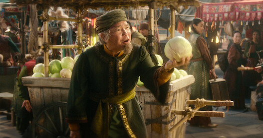 ames Sie as Cabbage Merchant holds a cabbage at a market in season 1 of 'Avatar: The Last Airbender'