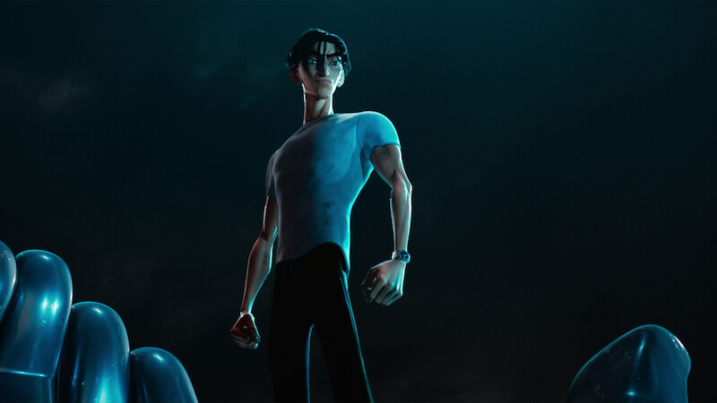 Ken Sato (Christopher Sean) wears a tight gray T-shirt and stands against a black background.