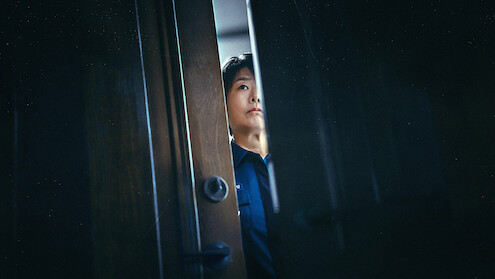 Lee Jung-eun as Yoon Bo-min looks through a slightly opened door in an image from the series 'The Frog.'