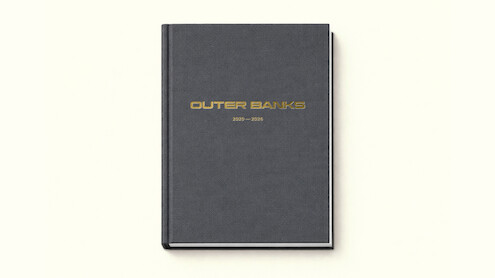 A black hardcover book with gold "Outer Banks 2020–2025" text on the cover, photographed on a plain off-white background.