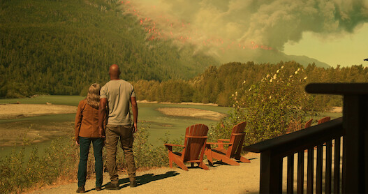 Annette O’Toole as Hope and Colin Lawrence as Preacher watch a wildfire blazes through the mountainside in Season 5 of 'Virgin River.'