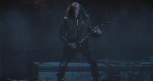 Eddie Munson playing guitar in a night scene.