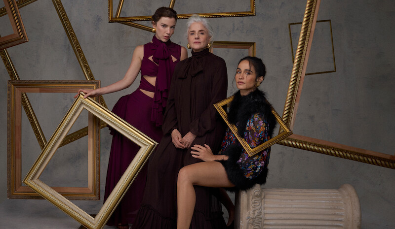 As atrizes Alice Wegmann, Marieta Severo e Nanda Costta posam para fotos em um ambiente repleto de molduras de quadro douradas