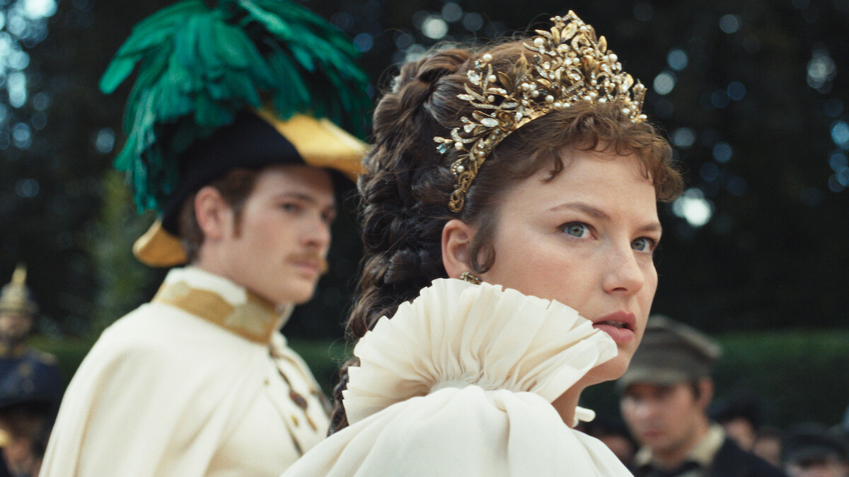 Devrim Lingnau as Elisabeth von Wittelsbach wears a gold crown and looks over her shoulder in Season 2 of 'The Empress'