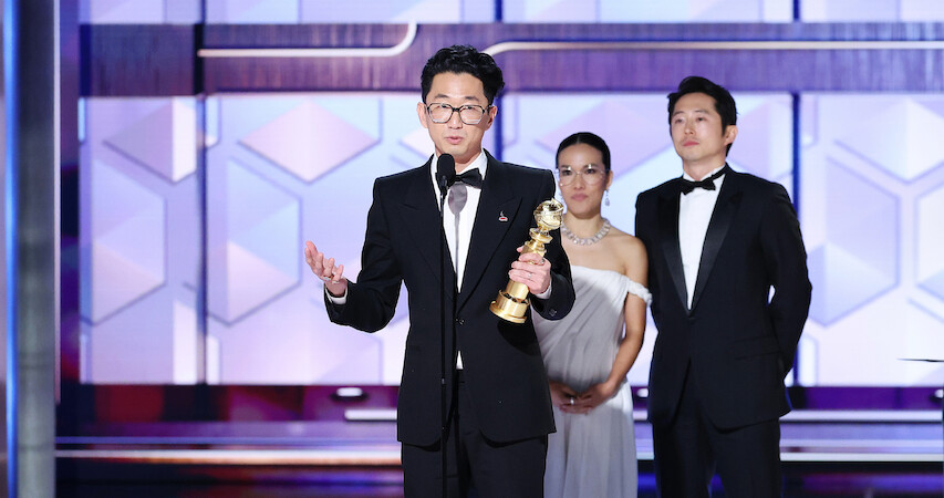 Lee Sung Jin accepting award on stage at the Golden Globes 2024.