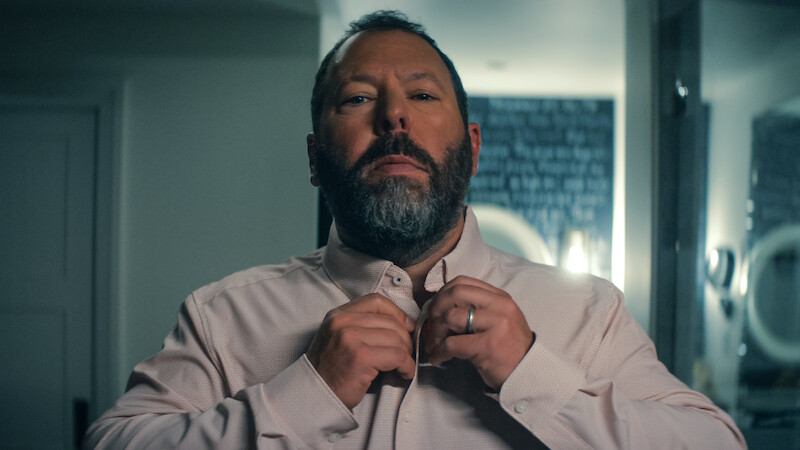 Bert Kreischer as Bert Kreischer buttoning up a shirt 'Free Bert.'