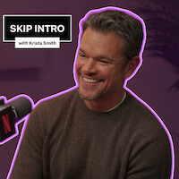 Matt Damon está sentado e sorri na frente de um microfone durante a gravação do podcast ‘Skip Intro with Krista Smith’. O plano de fundo é roxo e o logotipo do podcast aparece no canto superior esquerdo.
