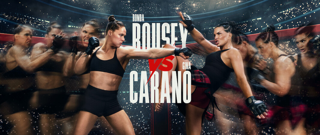 Two female MMA fighters face off in a dynamic action scene inside a stadium cage, with dramatic lighting and motion blur effects. A crowd and bright lights fill the background, text shows "Rousey vs Carano" in bold letters at the center.