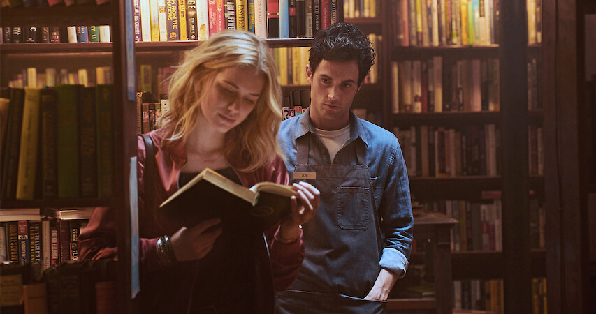 Joe (Penn Badgley watches Beck (Elizabeth Lail) in the bookstore