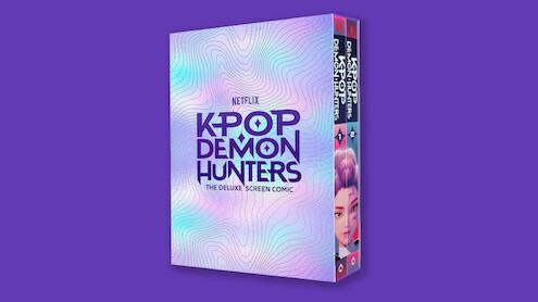 A deluxe screen comic box for Netflix's "Kpop Demon Hunters" is shown against a solid purple background, with iridescent pastel patterns and bold purple text on the cover.