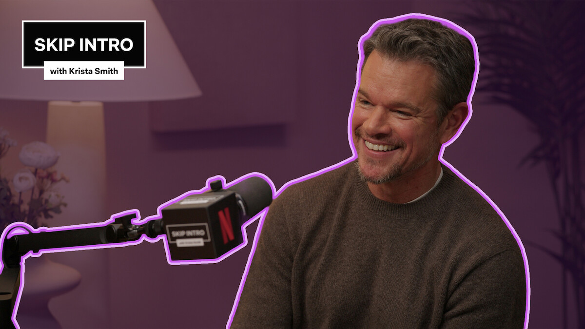 Matt Damon sits smiling in front of a microphone during a podcast recording for "Skip Intro with Krista Smith." The background is purple, and the podcast logo appears in the top left corner.