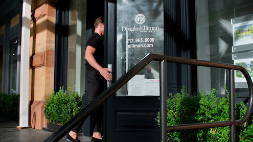 A Douglas Elliman agent enters the building.