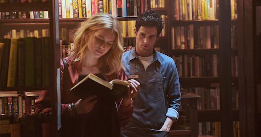 Joe (Penn Badgley watches Beck (Elizabeth Lail) in the bookstore