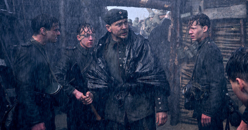 Soldiers standing in the rainy trenches in All Quiet on the Western Front.