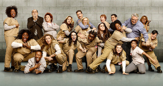 The cast of Orange Is the New Black Season 7 pose together playfully. 