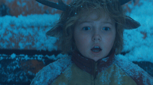Christian Convery as Gus sits covered in snow with a surprised expression in season 3 of 'Sweet Tooth'