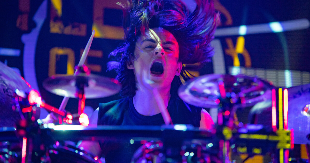 A main character rocking out on the drums in 'Metal Lords'