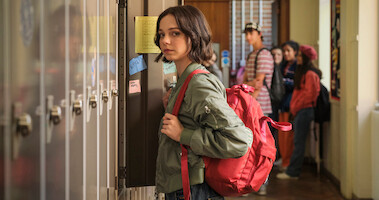 Emma Myers as Pip Fitz-Amobi stands in a high school hallway in front of a wall of lockers in ‘A Good Girl's Guide to Murder.’