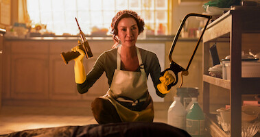 Michelle Yeoh as Eileen Sun holds a drill and saw in a kitchen while wearing a hairnet in Season 1 of 'The Brothers Sun'