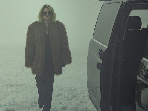 Jessi (Selena Gomez) wears a fur jacket and walks through the snow.