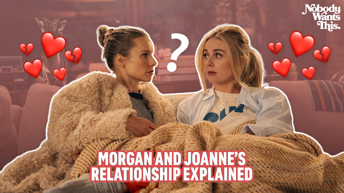 Joanne (Kristen Bell) and Morgan (Justine Lupe) sit close together on a couch, looking at each other with curiosity and affection, surrounded by heart icons and a question mark. Cozy and warm atmosphere.