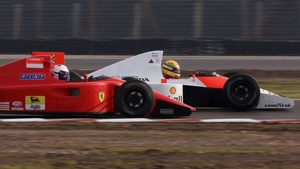 A warehouse with three F1 car models