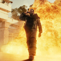 A man standing in front of an explosion of fire