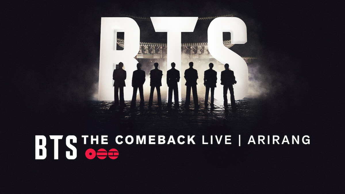 Silhouettes of seven people standing in front of large lit-up BTS letters with "BTS THE COMEBACK LIVE | ARIRANG" text at the bottom, dark concert stage background.