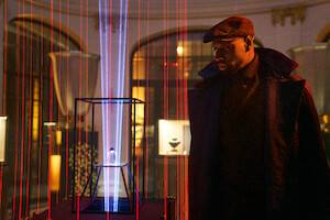 Omar Sy, no papel de Assane Diop, encara um objeto misterioso cercado por lasers vermelhos na temporada 3 de ‘Lupin’.