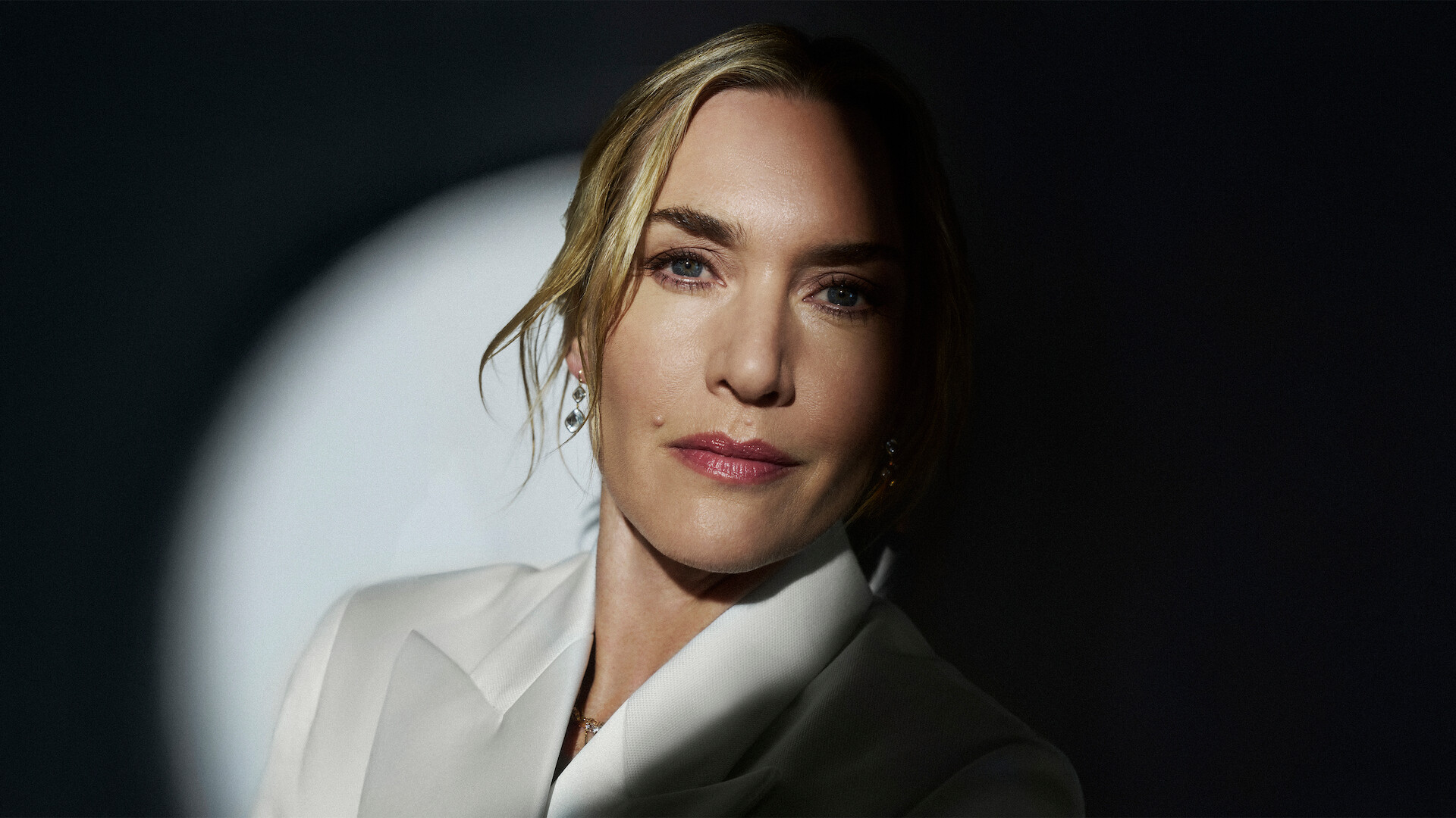 Kate Winslet with a spotlight on her face.