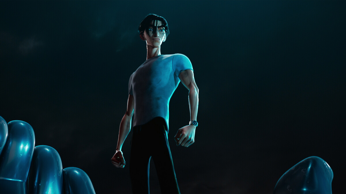 Ken Sato (Christopher Sean) wears a tight gray T-shirt and stands against a black background.