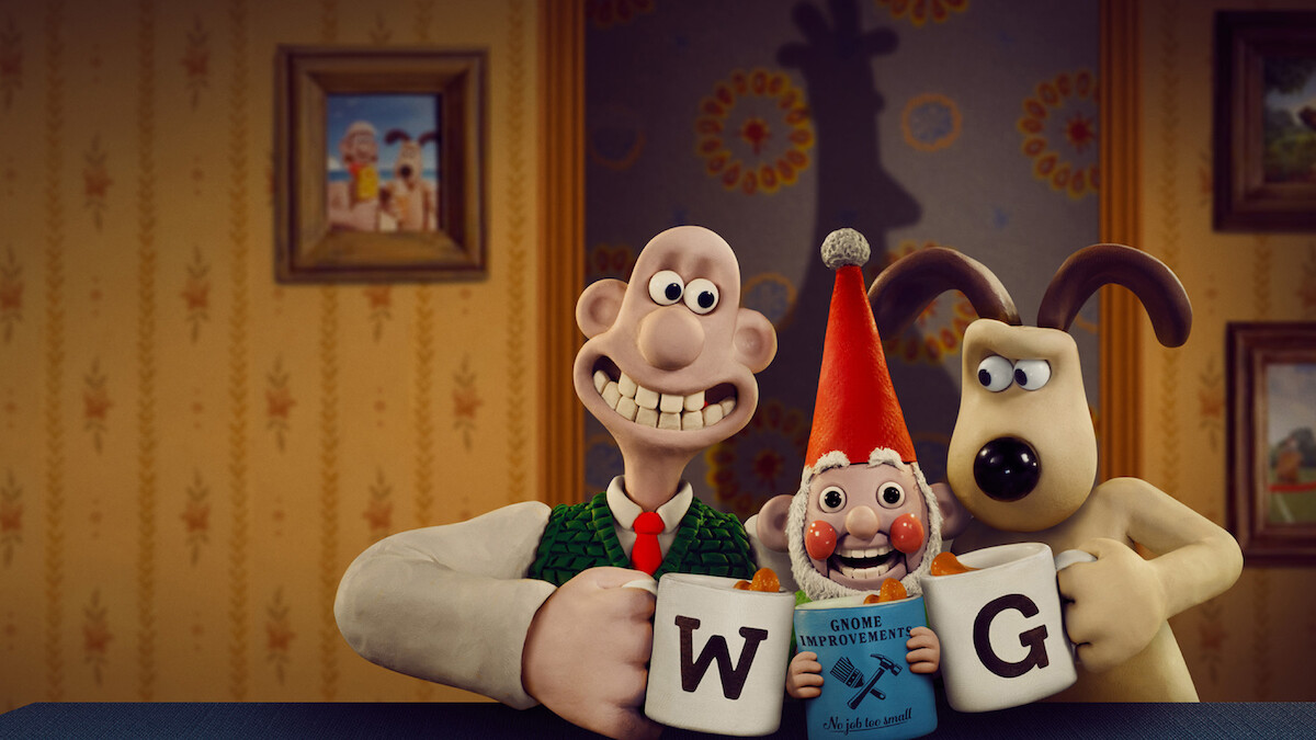 Wallace and Gromit clink mugs with a gnome sitting between then.