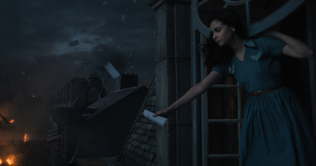All the Light We Cannot See - a woman in a blue dress looking out on a burning city