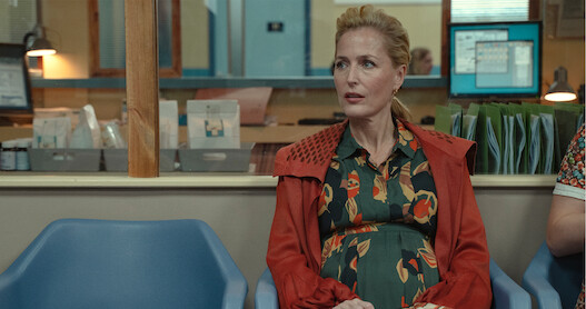 Gillian Anderson as Jean Milburn sits in the waiting room of a doctor's office while pregnant in Season 3 of ‘Sex Education.’