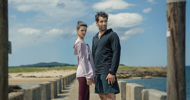 Clara Lago as Ana and Tamar Novas as Daniel stand together on a dock in 'Gangs of Galicia'