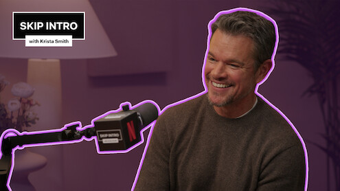 Matt Damon sits smiling in front of a microphone during a podcast recording for "Skip Intro with Krista Smith." The background is purple, and the podcast logo appears in the top left corner.