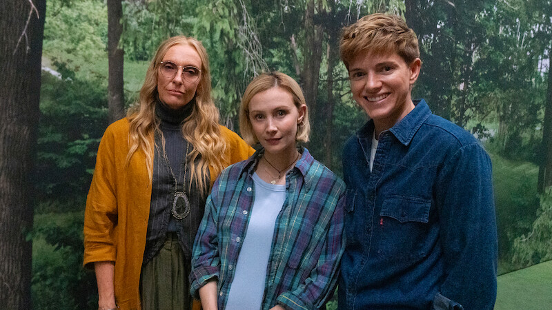 Toni Collette, Laura Redman, and Mae Martin stand together in front of a forest mural in Season 1 of 'Wayward'