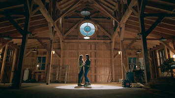 Alexandra Breckenridge como Mel e Martin Henderson como Jack dançam juntos em um celeiro na temporada 6 de 'Virgin River'
