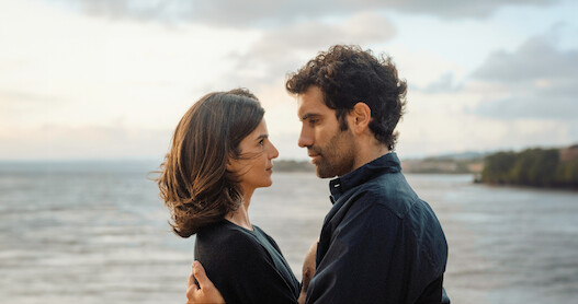 Clara Lago as Ana and Tamar Novas as Daniel embrace on the beach in 'Gangs of Galicia'