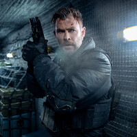 Chris Hemsworth as Tyler Rake with a bruised face and tactical gear holding a handgun, standing alert in a dimly lit, metal-walled corridor with supplies and fluorescent lighting, appearing ready for action or conflict.