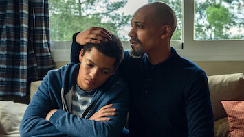 A father and son share a moment together while seated. 