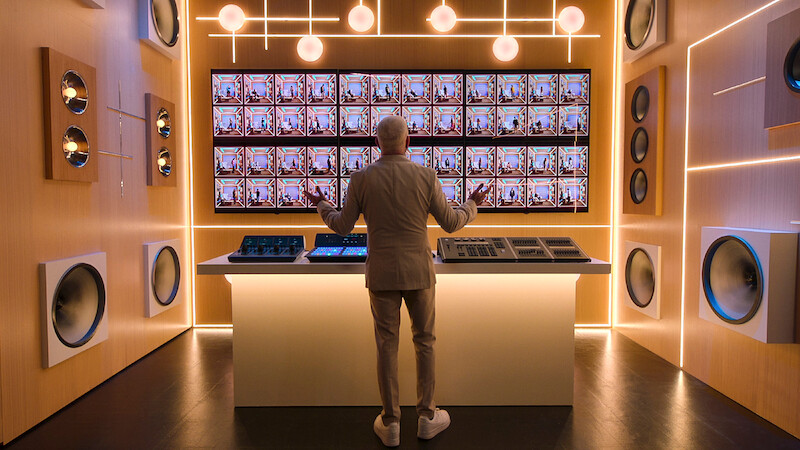 AJ McLean stands in front of a screen featuring the 'Building the Band' Season 1 booths.