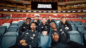 Sidemen seated in the stands of a stadium.