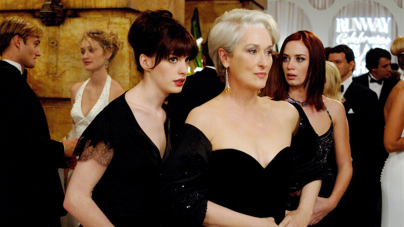 Andy (Anne Hathaway, left) whispers some important information to her boss, fashion magazine editor Miranda Priestly (Meryl Streep), as Miranda's first assistant, Emily (Emily Blunt) looks on. TM and © 2006 Twentieth Century Fox. All rights reserved.