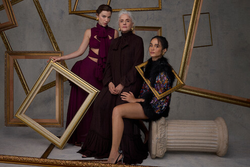 As atrizes Alice Wegmann, Marieta Severo e Nanda Costta posam para fotos em um ambiente repleto de molduras de quadro douradas