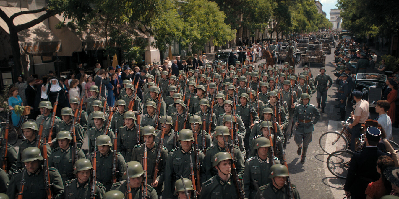 A street filled with columns of soldiers marching. 