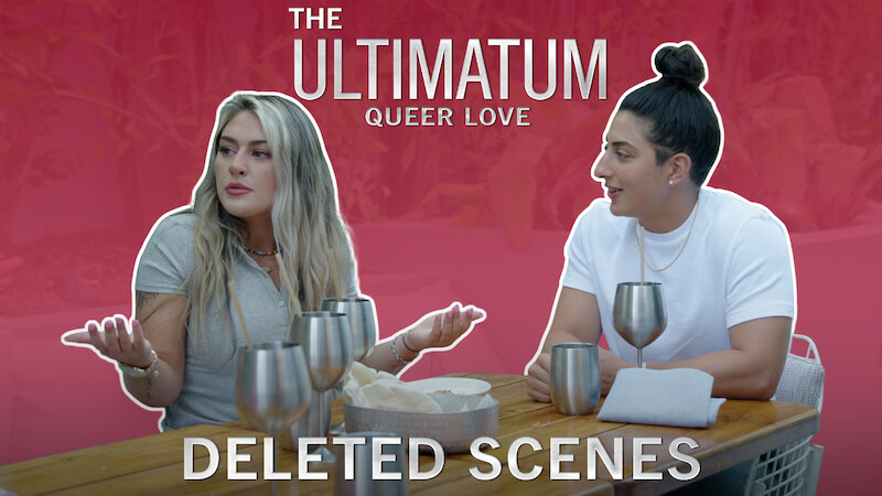 Dayna and Magan seated at a wooden table with metallic cups against a red background. The text reads: 'The Ultimatum: Queer Love – Deleted Scenes.'