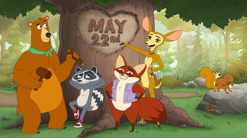 Four cartoon animals—a bear, raccoon, fox, and deer—stand by a large tree in a forest with "May 22nd" carved in its trunk. Two squirrels are on a rock in the background. The setting is bright and cheerful.