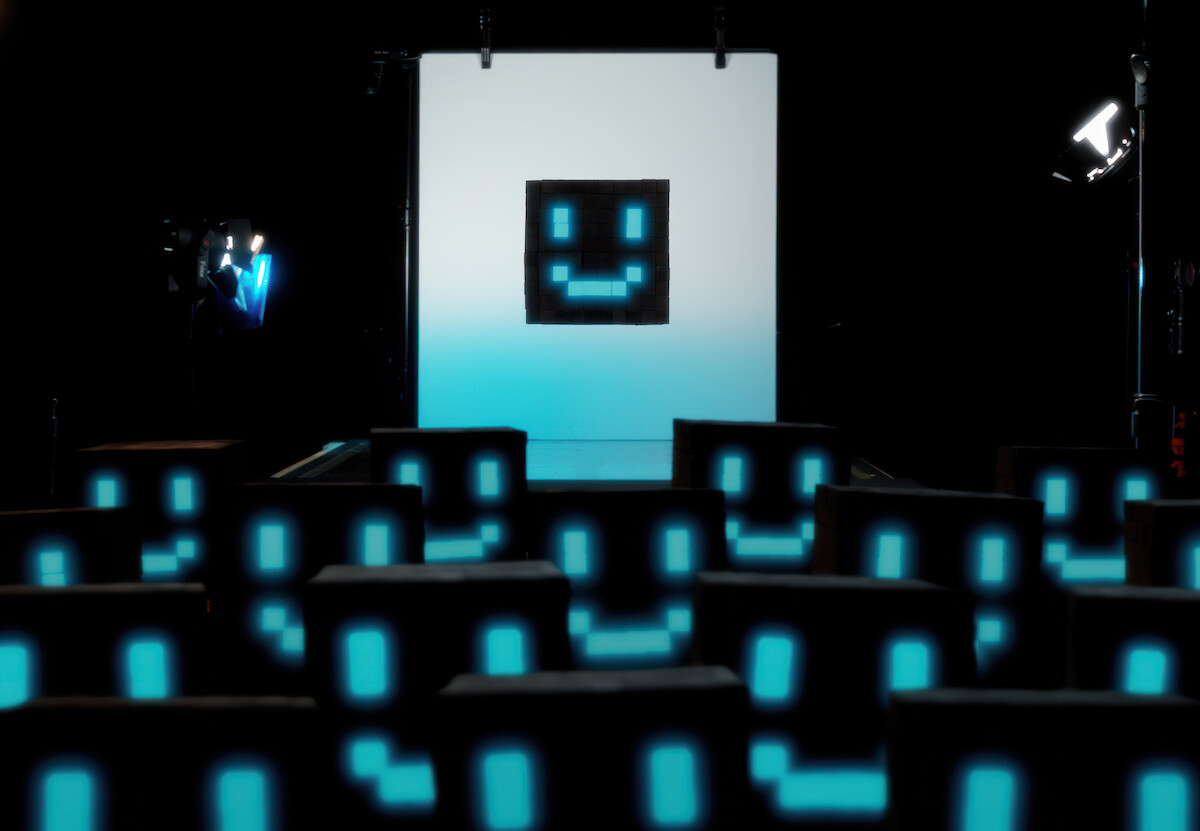 Imagem mostra várias representações de uma inteligência artificial, um cubo preto com olhos e boca luminosos