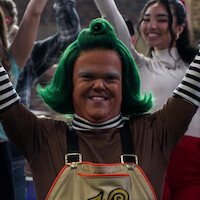 Contestant with Wonka's Golden Ticket next to an Oompa Loompa